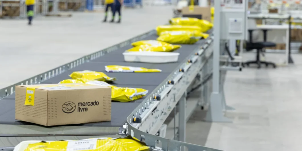 Imagem de um centro de distribuição do Mercado Livre mostra uma esteira com produtos embalados com a marca da empresa