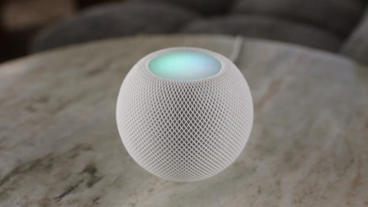 HomePod Mini sobre uma mesa de mármore. Trata-se de uma caixa de som branca em formato esférico 