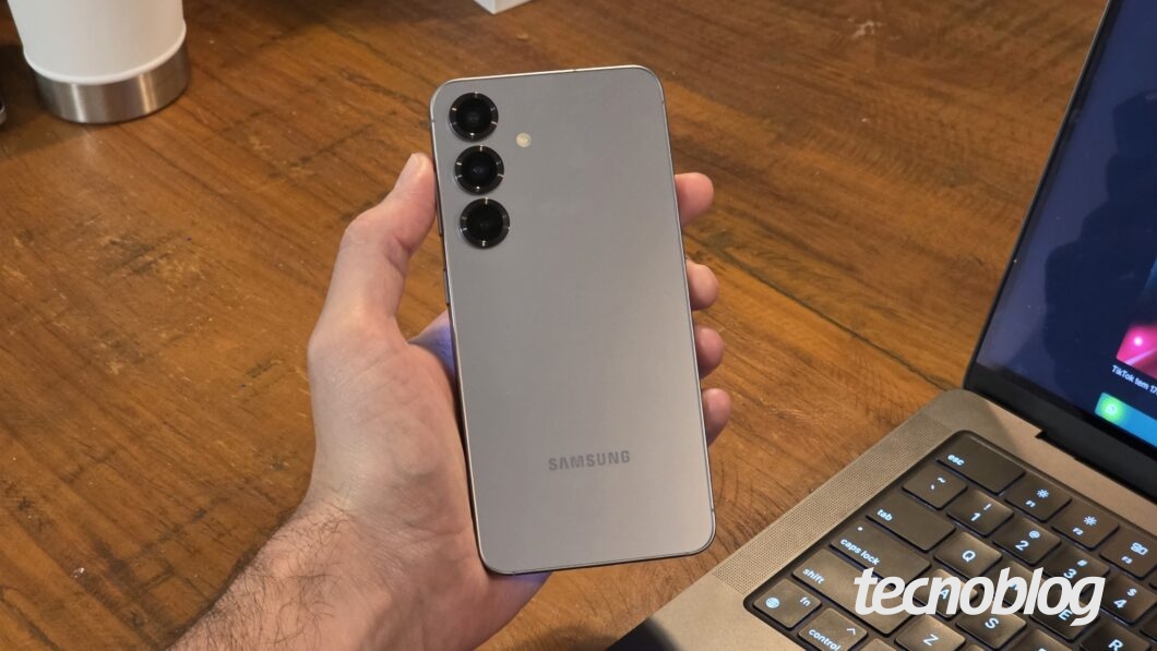 Mão segurando o Galaxy S25, mostrando a traseira com as câmeras